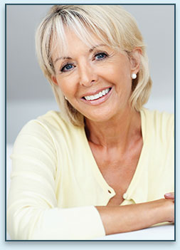 older blonde smiling woman in pale yellow sweater