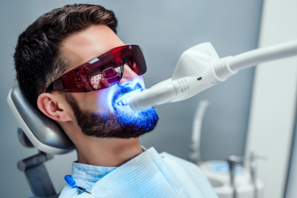 man in dental chair getting teeth professionally whitened