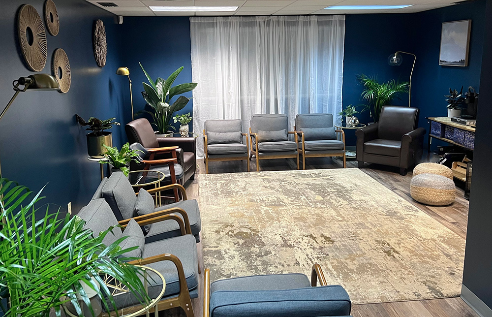 The Savannah Dental waiting room, with dark blue walls and comfortable furniture.